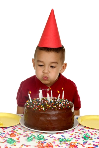 child blowing out birthday candles