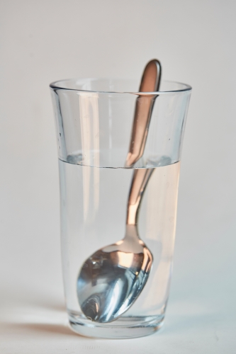 light refracting on spoon in glass